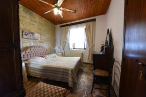 a bedroom with a bed and a ceiling fan at Jeannet's Beach House in Amarynthos