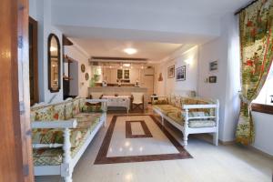a living room with two couches and a kitchen at Jeannet's Beach House in Amarynthos