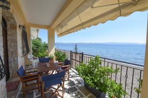 balkon ze stołem i krzesłami oraz oceanem w obiekcie Jeannet's Beach House w mieście Amarynthos