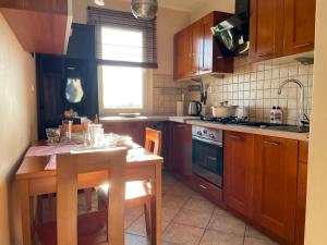 a kitchen with wooden cabinets and a wooden table with a tableablish at Sunny Apartament in Reda