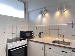 cocina con fregadero y microondas en One Bedroom Apartment In Rdovre, Trnvej 41b, 2, en Rødovre