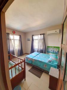a small bedroom with a bed and a crib at Fina Villa Apartments - Mont choisy in Mont Choisy