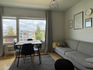 a living room with a couch and a table and chairs at Casa Marina Naantali in Naantali