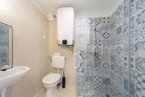 La salle de bains est pourvue de toilettes, d'un lavabo et d'une douche. dans l'établissement Tagyon Birtok Tulipános Apartman, à Tagyon