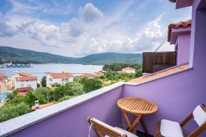 balkon z fioletowymi ścianami, stołem i krzesłami w obiekcie Villa Lavanda w mieście Cres