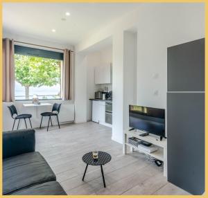 a living room with a couch and a table at Appartement Cozy 2 Panoramique Lac Léman Thonon-Les-Bains in Thonon-les-Bains