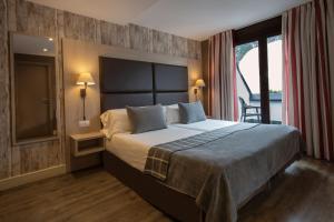 索尔德乌Hotel Himàlaia Soldeu的一间带大床和大窗户的卧室