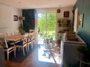 eine Küche und ein Esszimmer mit einem Tisch und Stühlen in der Unterkunft la villa provençale in La Motte-Chalançon