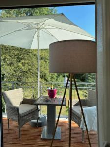 une table, des chaises et un parasol sur une terrasse dans l'établissement Deluxe Apartment Goldsteinkoje 2, à Bad Nauheim