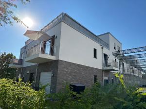 un bâtiment blanc avec un balcon au-dessus dans l'établissement Deluxe Apartment Goldsteinkoje 2, à Bad Nauheim