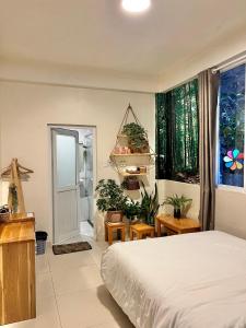 um quarto com uma cama e vasos de plantas em Nhà An Đà Lạt em Da Lat