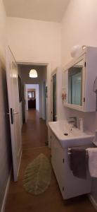 een badkamer met een wastafel en een spiegel en een hal bij Appartamento Viale Puccini - Free Gated Parking - 3 Minutes from Center in Lucca