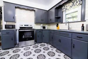 eine Küche mit blauen Schränken und Fliesenboden in der Unterkunft Cozy 5BR Home minutes from the falls in Niagara Falls