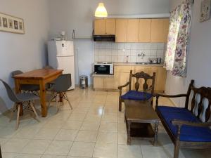 een keuken met een tafel en stoelen en een keuken met een koelkast bij Agni in Nafpaktos