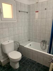 a bathroom with a toilet and a bath tub at Agni in Nafpaktos