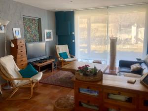 ein Wohnzimmer mit einem Sofa und einem TV in der Unterkunft la villa provençale in La Motte-Chalançon
