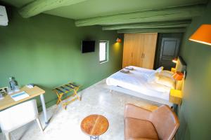 a bedroom with a bed and a desk and a chair at Hotel La Bastide d'Eygalières in Eygalières