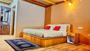 a bedroom with a bed with red pillows on it at Mystic Pangong in Spangmik