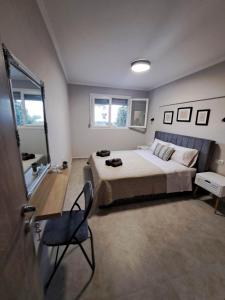 a bedroom with a bed and a chair in it at Elegance apartment in Paleo Tsifliki