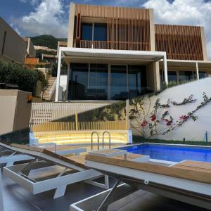 a house with a swimming pool in front of a building at Vila 122B Palase Privat Pool in Himare