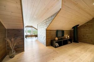 an attic room with a fireplace and a tv at Hytte Eribo in Lona