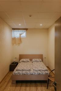 1 dormitorio con 1 cama en una habitación con ventana en Guest house Baltika en Ventspils