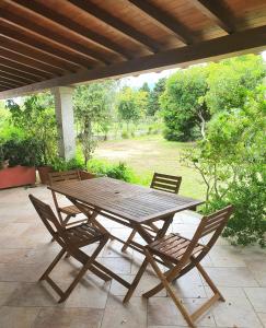a wooden table and chairs on a patio at Pareja Apartments in Orosei