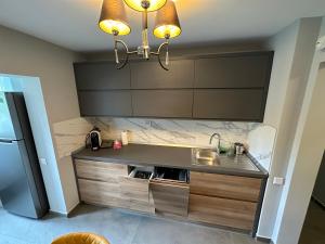 a kitchen with a sink and a chandelier at Page1 Ultracentral Apartament in Târgovişte