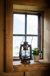 eine Laterne, die auf einem Fensterbrett neben einer Pflanze sitzt in der Unterkunft Ferienhaus Chalet Steckli in Brienz