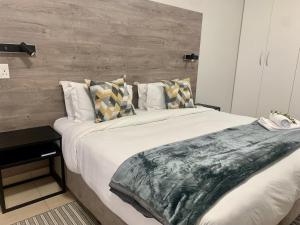 sypialnia z dużym łóżkiem i drewnianą ścianą w obiekcie Woodbridge Lodge w Kapsztadzie