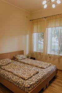 1 dormitorio con 2 camas y ventana en Guest house Baltika en Ventspils