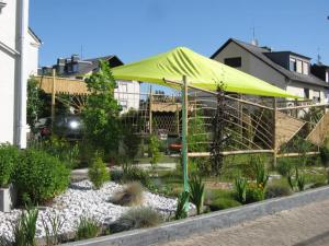 a yellow umbrella in a garden in front of a house at Diamanthaus 3 Koblenz in Koblenz