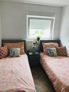 two beds sitting next to each other in a bedroom at Rab,new Apartman in Rab