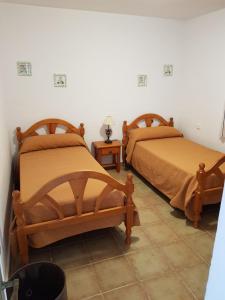 a bedroom with two beds and a tiled floor at Urbanización las Torres Apartamento in Chiclana de la Frontera