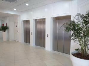 a hallway with elevators and a potted plant in a building at Gran Hotel Flamingo-Adults Only older 18 years old in Lloret de Mar