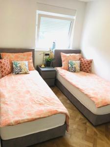 a bedroom with two beds and a window at Rab,new Apartman in Rab