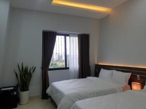 Thôn Trường Giang的住宿－Ourhome，酒店客房设有两张床和窗户。