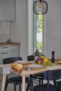a table with a plate of bread and fruit on it at Domki Premium Nautica blisko plaży in Rewal