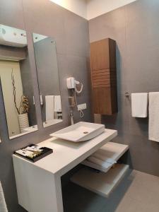 a bathroom with a white sink and a mirror at BLOSSOM Studio in Manesar