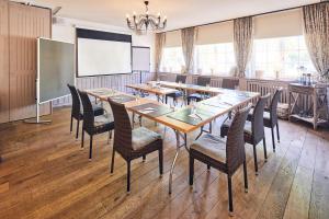 a conference room with tables and chairs and a projection screen at Hotel & Restaurant Grenzhof in Heidelberg