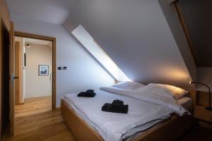 Un dormitorio con una cama con dos bolsas negras. en TATRYSTAY Luxury Penthouse Apartment PodLesom, en Dolný Smokovec