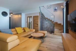 a living room with a couch and a table at TATRYSTAY Luxury Penthouse Apartment PodLesom in Vysoke Tatry - Dolny Smokovec