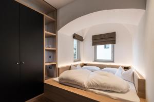 a bedroom with a large bed with a window at Alpin & Stylehotel Die Sonne in Parcines