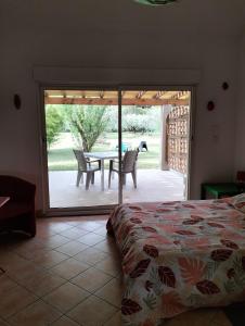 een slaapkamer met een bed en een tafel en een patio bij Petit Mazet Fruits rouges in Eyragues