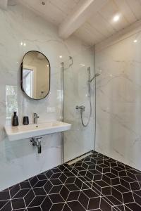 a bathroom with a shower and a sink and a mirror at Domki Premium Nautica blisko plaży in Rewal +37 photos