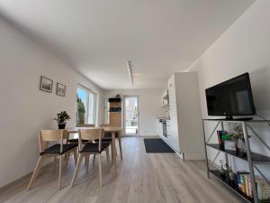 uma sala de jantar com mesa e cadeiras e uma televisão em Apartment Sunshine em Höchst