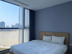 a bedroom with a bed and a large window at Vinhomes Skylake Luxury Apartment 3 Br in Hanoi +69 photos