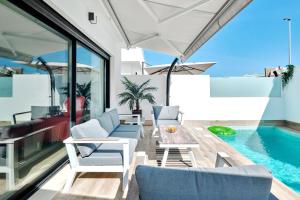 a patio with a table and chairs and a swimming pool at Villa del Pinatar heated private pool in San Pedro del Pinatar