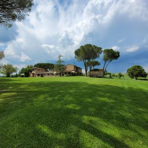 een groot groen veld met een huis op de achtergrond bij Casanova di Campriano in Lupompesi