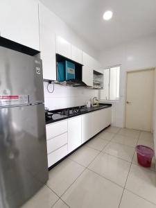 a kitchen with white cabinets and a stainless steel refrigerator at Pinnacle Tower Johor Bahru 3 Bed 2 Bath in Johor Bahru +3 photos